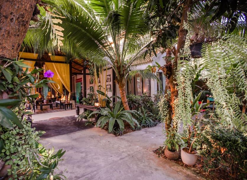 The Sanctuary Villa Battambang in Battambang courtyard with lush tropical plants and open-air seating