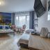 Royal Gdansk hotel room with cityscape mural, twin bed, sofa, desk and large window in Gdansk