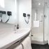 ibis Beijing Dongdaqiao bathroom with walk-in shower, sink, toilet, and black patterned accent wall in Beijing