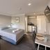 Countryman Motor Inn in Dubbo room with king bed, black sofa, desk and kitchenette