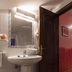 Hotel Villa de Cabrales bathroom with pedestal sink, mirror, and open door in Las Arenas