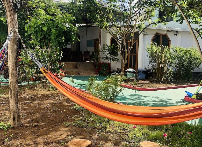 Hostal White House Galapagos in Puerto Ayora with colorful hammocks in a tropical garden