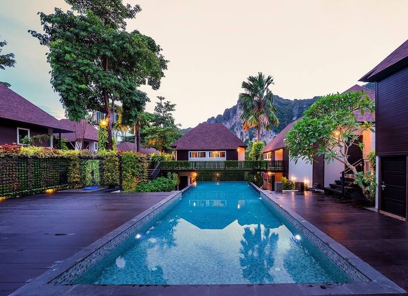 The Cliff Elegance Resort in Krabi: tropical courtyard pool at dusk with mountain backdrop