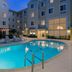 Homewood Suites by Hilton Bonita Springs Naples North pool courtyard at dusk in Bonita Springs