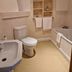 OYO The Leven Felixstowe bathroom with toilet, bidet, bathtub, towel shelves and wall art
