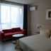 Jinjiang Inn (Huizhou Dadao Hefei) guest room with bed, red sofa, round table and window view in Hefei