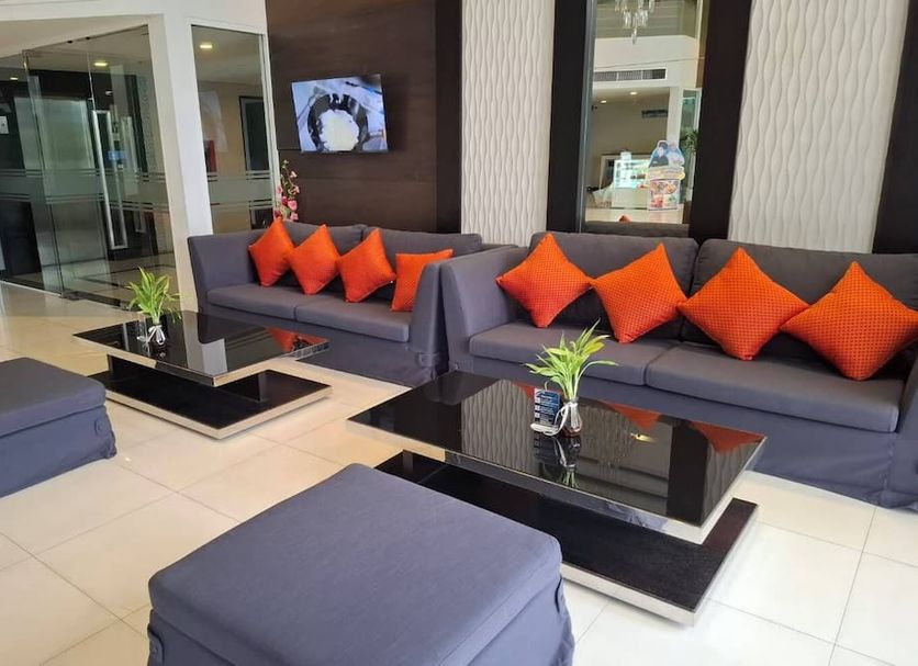 Crystal Suites Suvarnabhumi Airport lobby seating area with gray sofas and orange pillows in Bangkok