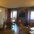 Hotel Le Centre in Brides-les-Bains dining room with round tables, wooden chairs, and wall-mounted TV