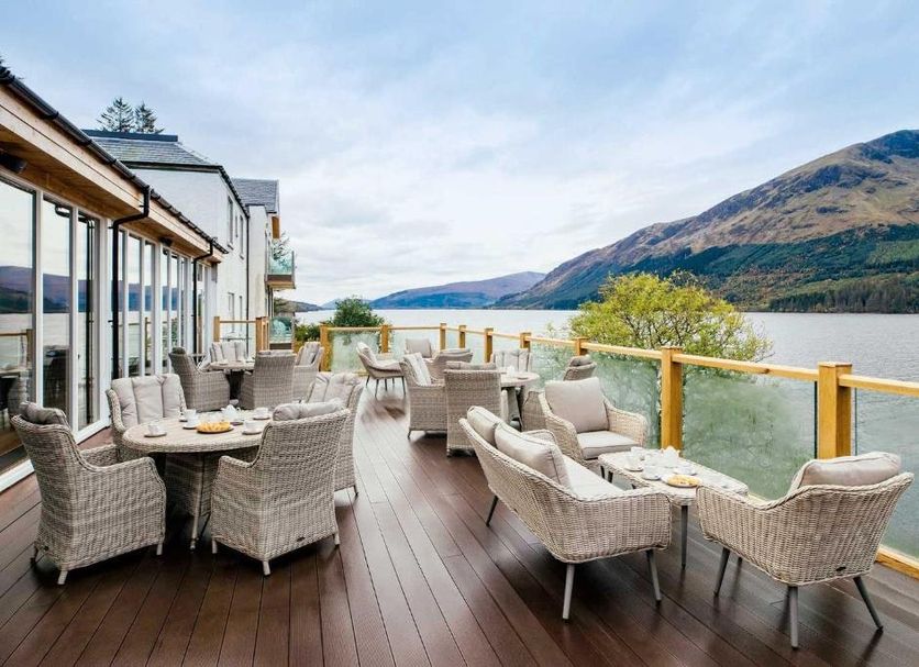 The Whispering Pine Lodge in Spean Bridge terrace seating overlooking a lake and mountains