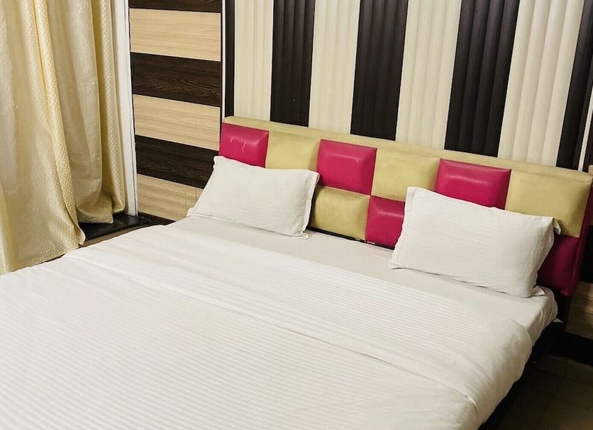 Hotel R S Residency, Amritsar: double bed with white linens and pink-accented headboard