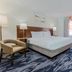 Fairfield Inn & Suites by Marriott Houston Westchase guest room with king bed, desk, and armchair