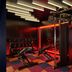 The Cura Hotel Kensington, London gym with weights, benches and cable machines in red lighting