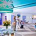 The Cabanas Hotel at Sun City Resort lobby with seating, reception desk, and guests chatting
