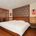 Education Hotel Guilin guest room with king bed, carved wood screen, and city-view window