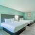 Lone Star Inn & Suites in Harlingen guest room with two beds, wall-mounted TV and desk