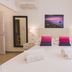 Dimore delle Zagare Ortigia, Siracusa: bright double bedroom with twin bedside lamps and sea view artwork