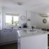 River Sands Apartments in Maroochydore: modern apartment kitchen and lounge with island bench and TV