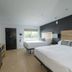 The Waypoint Rehoboth Beach guest room with two beds, TV, and balcony view