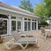 Mill Creek Hotel in Lake Geneva: sunny wooden deck with lounge chairs, patio tables and trees