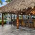 Thatched tiki bar at Club Wyndham Sea Gardens in Pompano Beach with tall stools and hanging lanterns