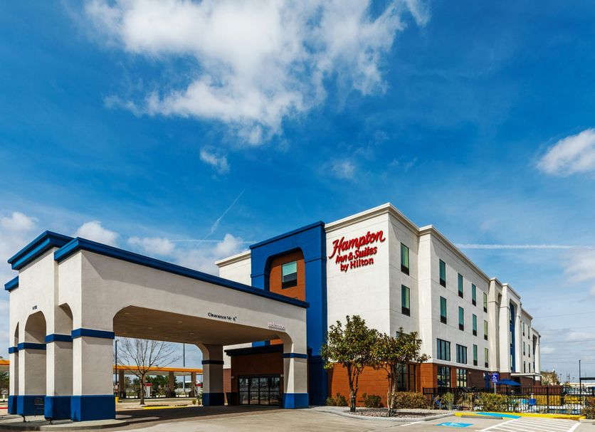 Hampton Inn & Suites by Hilton Tomball Houston NW exterior with covered entrance and blue accents in Tomball