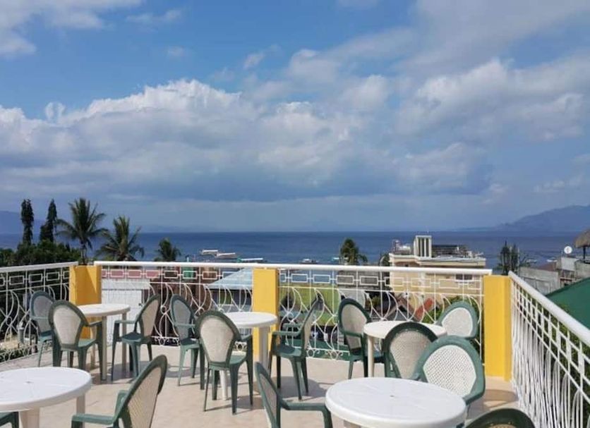 Sabang Oasis Resort in Puerto Galera rooftop terrace with tables, chairs, and ocean views