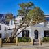 Cape Cadogan Boutique Hotel in Cape Town with white facade, balcony, and tree-lined street frontage
