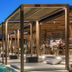 Rocabella Mykonos Hotel in Agios Stefanos, poolside cabanas beside a lit infinity pool at dusk