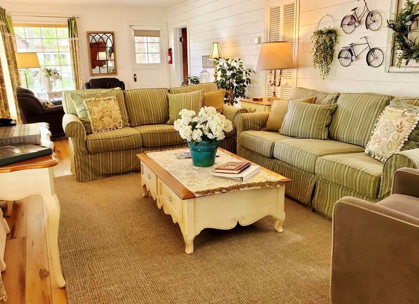 Adorable Lake Street Cottage in Sandpoint living room with striped sofas, coffee table, and wall-mounted bikes