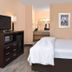 La Bonita Inn & Suites - Mccamey guest room with king bed, TV, and vanity in McCamey