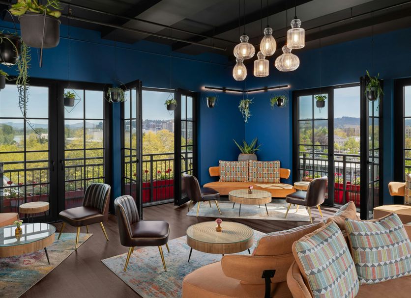 The Gordon Hotel in Eugene rooftop lounge with city views, blue walls, and hanging pendant lights