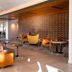 Andaz Scottsdale Resort & Bungalows lobby lounge with brick wall, yellow chairs and wood bench seating