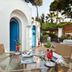 Grand Hotel Il Moresco in Ischia: outdoor terrace with glass table, rattan chairs, and arched blue doors