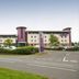 Premier Inn Newcastle Airport in Newcastle upon Tyne, exterior view beside a road and landscaped greenery