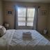 Happy Valley House Phoenix guest room with king bed, window blinds, and framed wall art