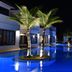 Sai Naam Lanta Residence in Ko Lanta, night view of palm trees surrounding a blue-lit pool