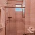 Pampulha Flat bathroom in Belo Horizonte with pink tile shower, towel rack, window and mirror