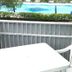 Residence Valbella Bibione balcony with white table and chair overlooking pool and greenery