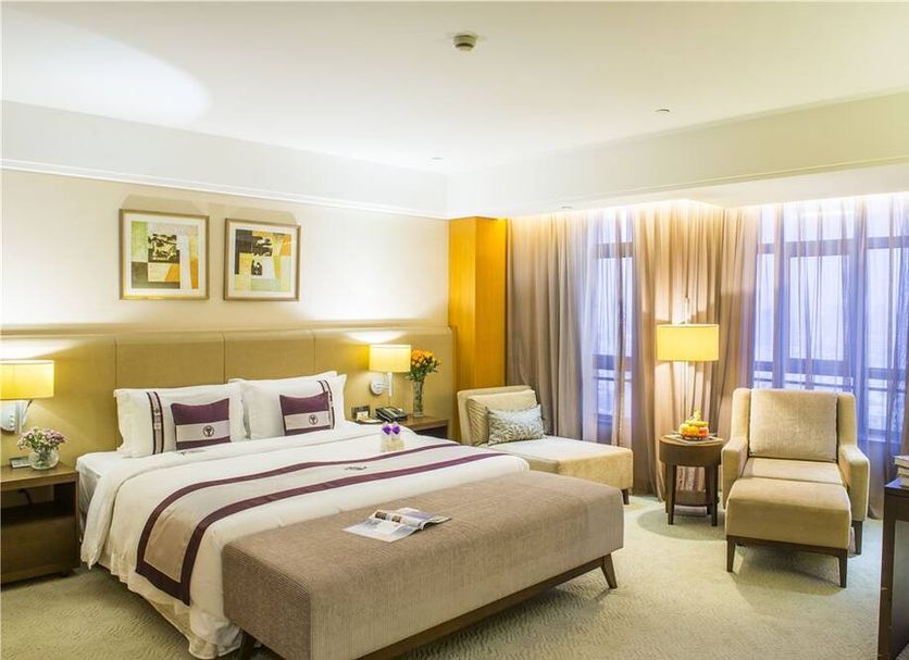 Windsor Park Hotel Kunshan guest room in Suzhou with twin beds, lounge chair, and large window