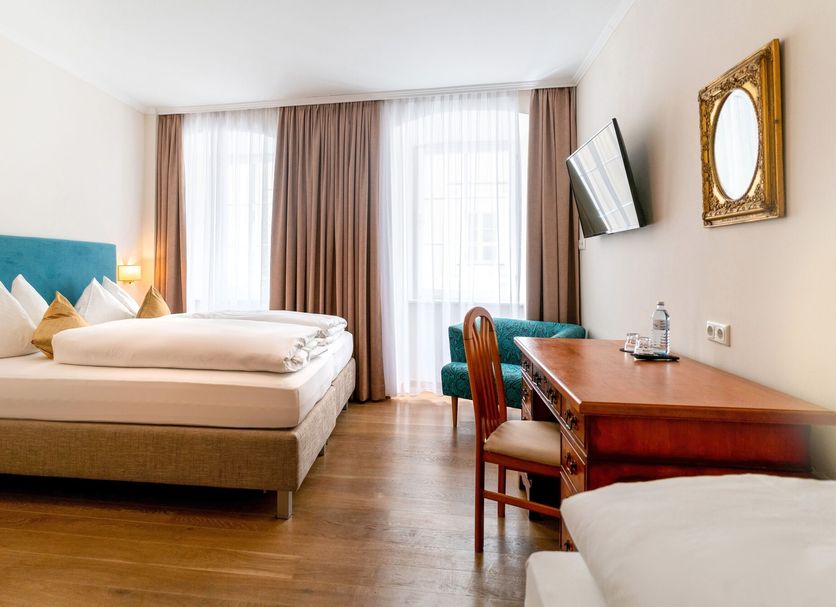 Cityhotel Trumer Stube Salzburg guest room with bed, desk, chair, and large window