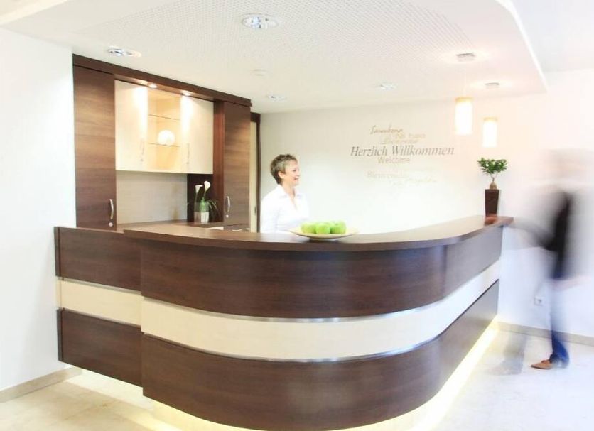 Klozbücher - Das Landhotel reception desk in Ellwangen with staff member and guest