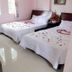 Ban Mai Hotel 66 Phan Thiet guest room with two flower-decorated beds and chairs near a window