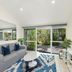 Caribbean Noosa in Noosa Heads living room with sofa, coffee table, wall TV and sliding doors to garden patio