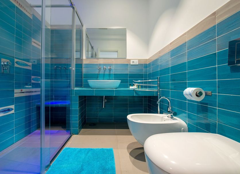 Casa Evelina Sorrento bathroom with blue tiled walls, glass shower, bidet and sink in Sorrento