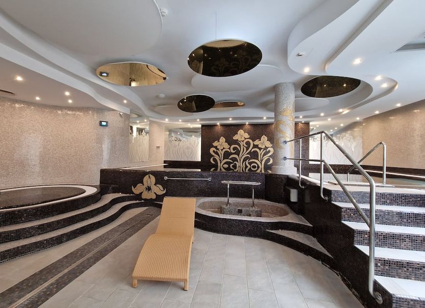 Spa Hotel Iris in Carlsbad spa area with lounge chair, pools, steps, and ornate ceiling details