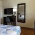 Motel 6 Lufkin guest room with bed, wall-mounted TV, desk, and mirror