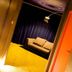Justbeds Bangkok hallway view into a lounge with sofa, dark curtains and warm ambient lighting