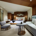 TRS Coral Hotel in Cancún: modern suite with king bed, sofa seating, and warm wood paneling