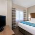 Hawthorn Extended Stay by Wyndham Naples guest room with king bed, window, and bedside lamps