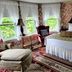 Moseley Cottage Inn and The Town Motel guest room in Bar Harbor with floral wallpaper, bay window, and armchair